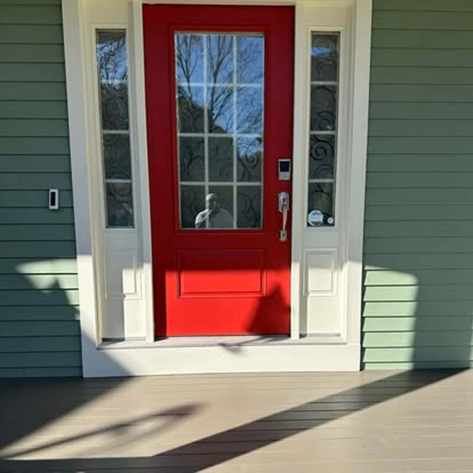 The front door of a house with a red door and white trim.