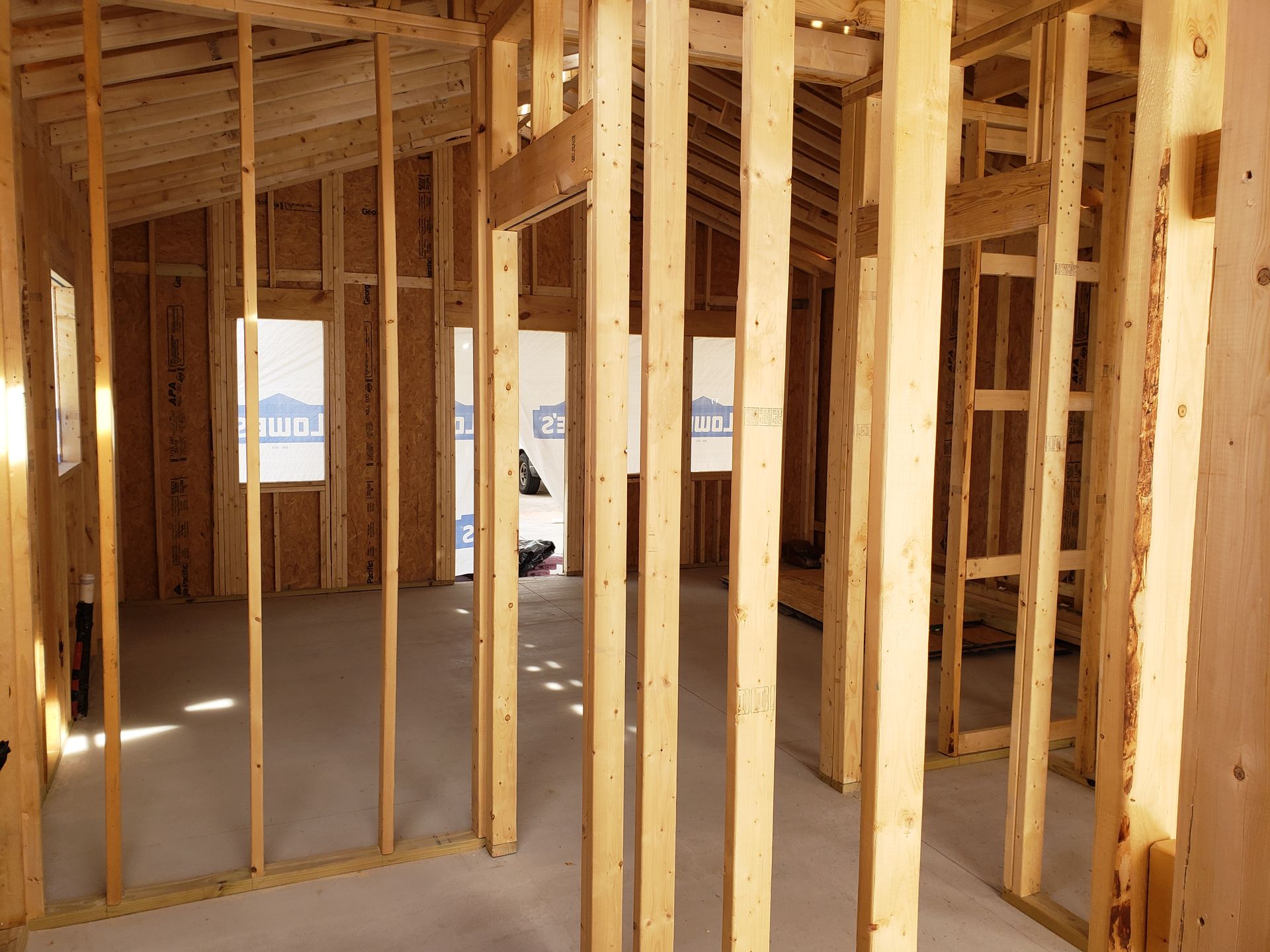 Interior of a house under construction; wooden studs and exposed framing.