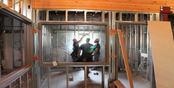 A group of people are standing in a room under construction.