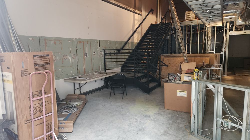 Construction management team working on interior stair install and framing in commercial build-out.