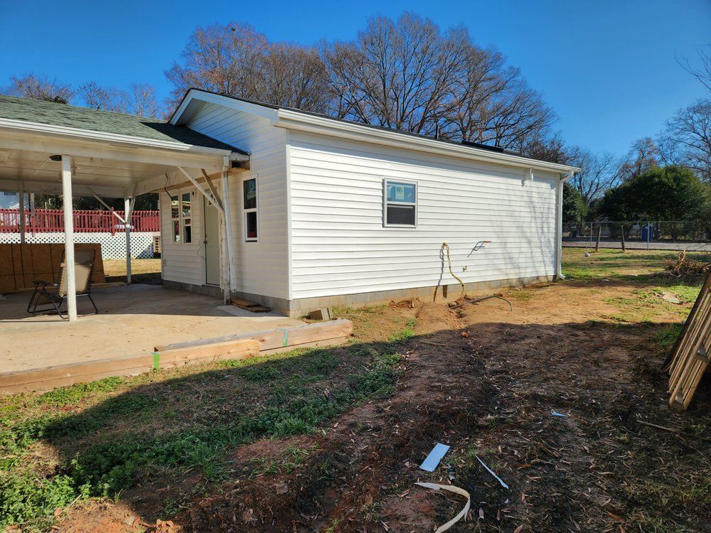 Completed custom home construction featuring white siding, patio cover, and clean exterior detailing.