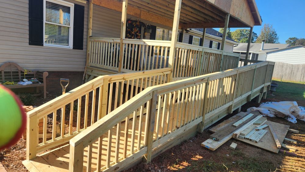 Wooden ramp and deck attached to a house with handrails.