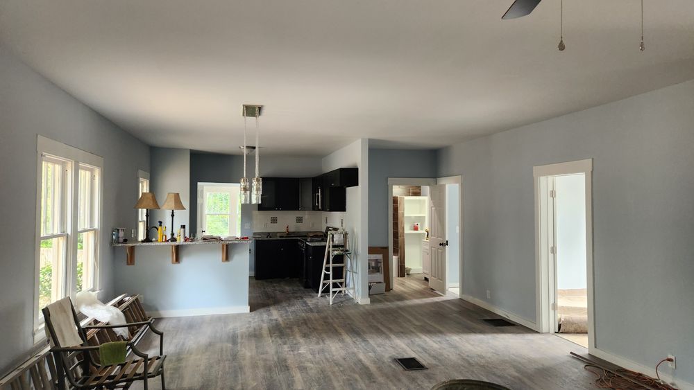 Home remodeling construction showing open concept layout with updated kitchen and living space in progress.