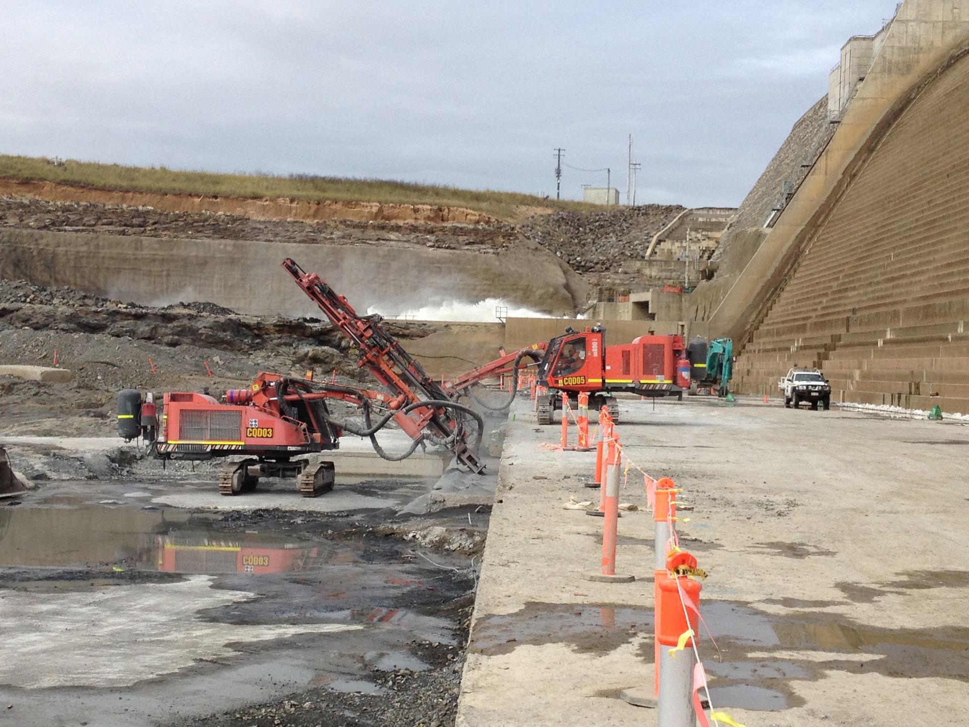 A red excavator is working on a construction site