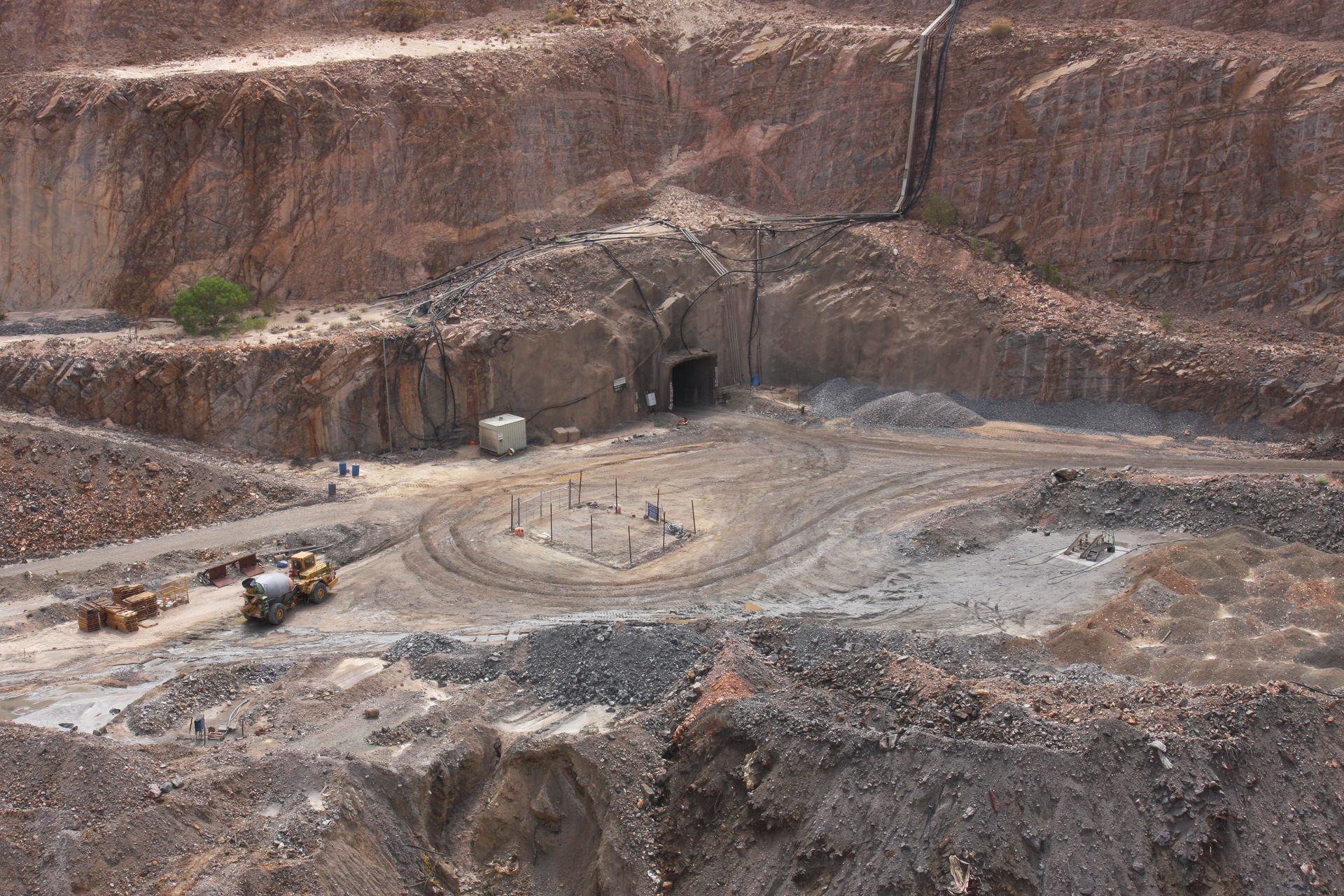An aerial view of a quarry with a tunnel in the background
