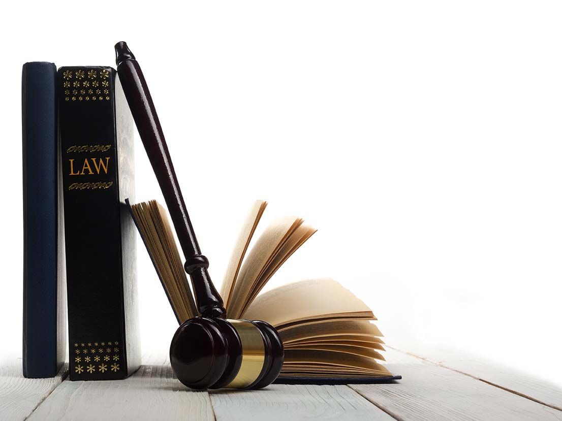 A stack of law books and a gavel on a table