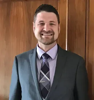 A man in a suit and tie is smiling for the camera.