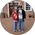 A man and a woman are posing for a picture in front of a building.