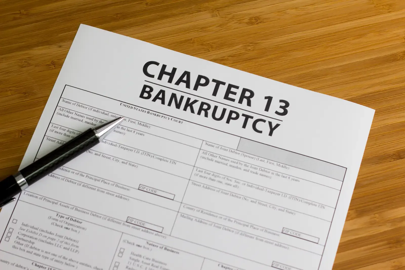 A pen is sitting on top of a chapter 13 bankruptcy form