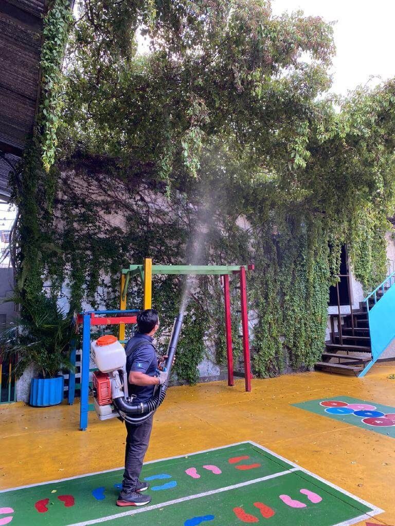 Una persona con una camisa oscura utiliza un pulverizador de mochila 