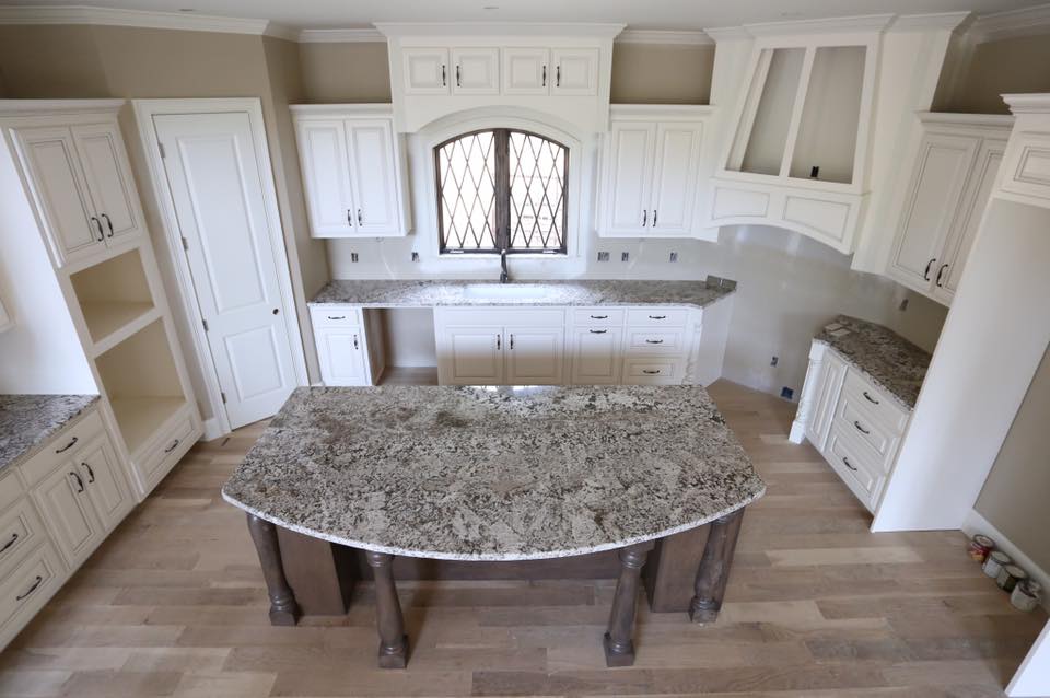 A kitchen with white cabinets and granite counter tops