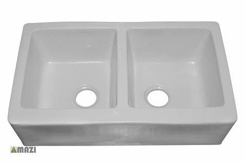 A white kitchen sink with two holes in it on a white background.