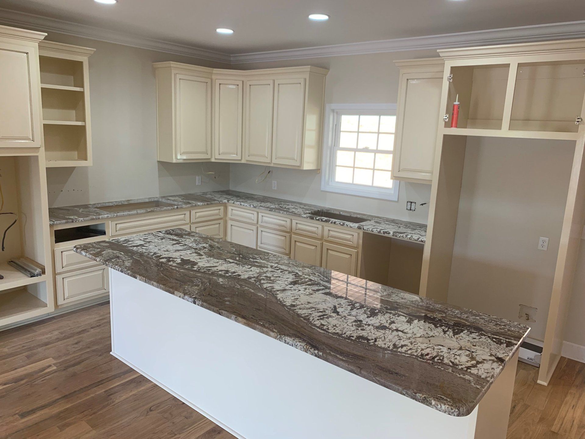 A kitchen with granite counter tops and white cabinets.