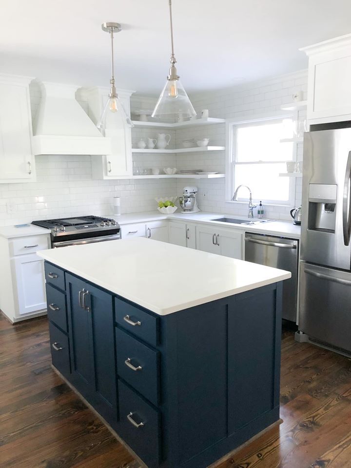 A kitchen with blue cabinets and white counter tops