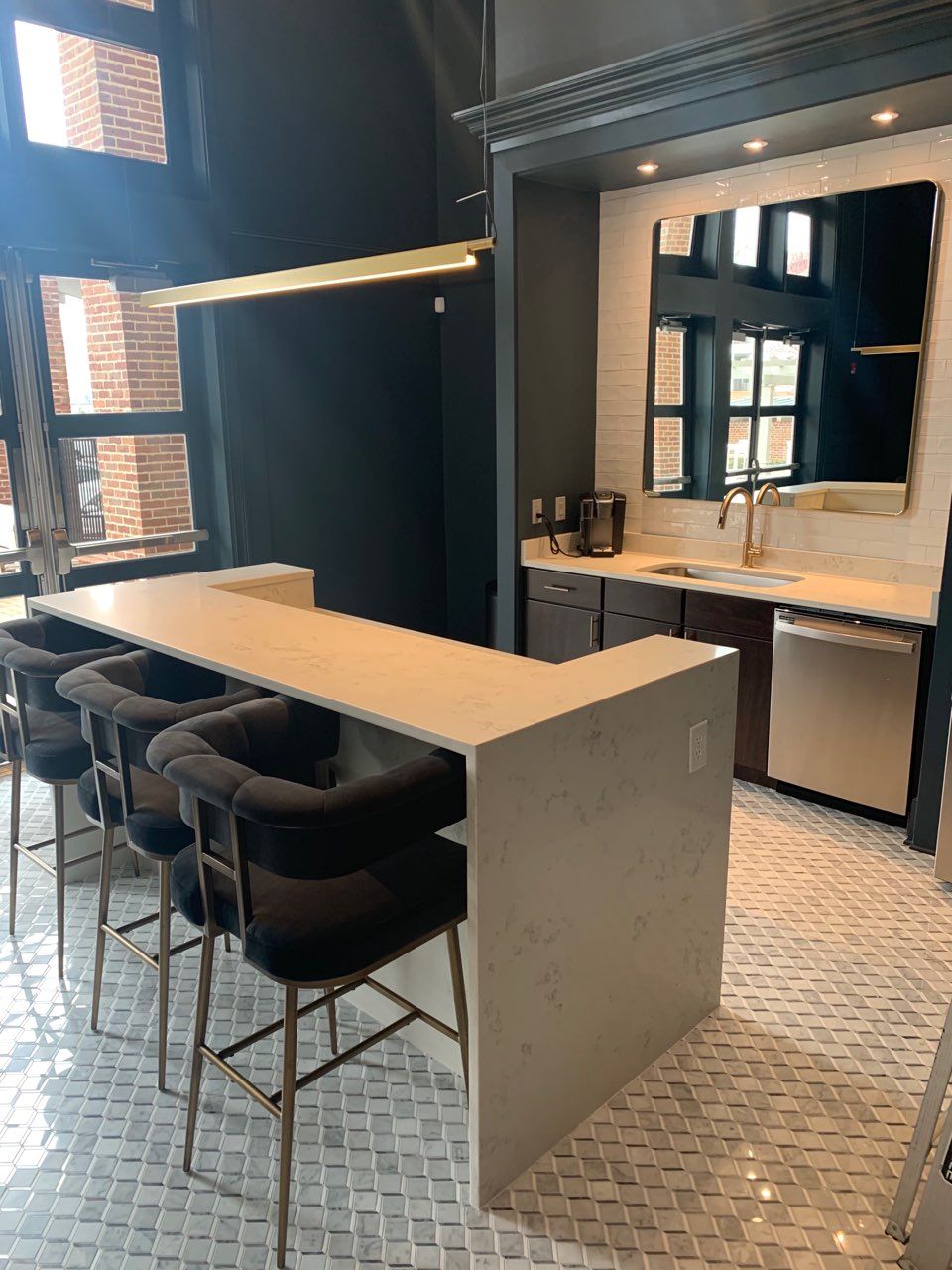 A kitchen with a long table and chairs in it.