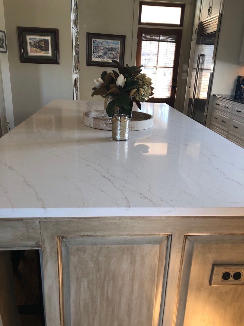 A white counter top with a vase of flowers on it