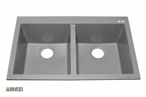 A gray kitchen sink with two holes in it on a white background.