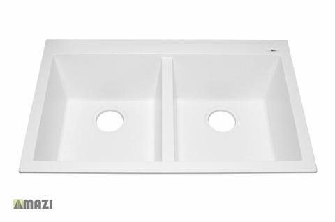 A white kitchen sink with two holes in it on a white background.
