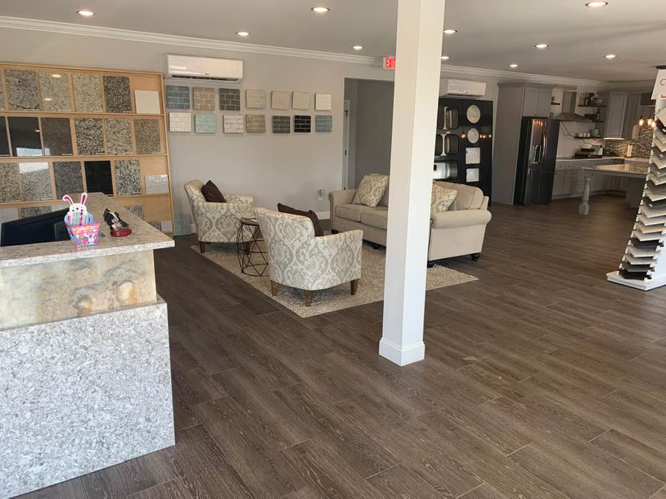 A living room with a couch , chairs , and a counter.