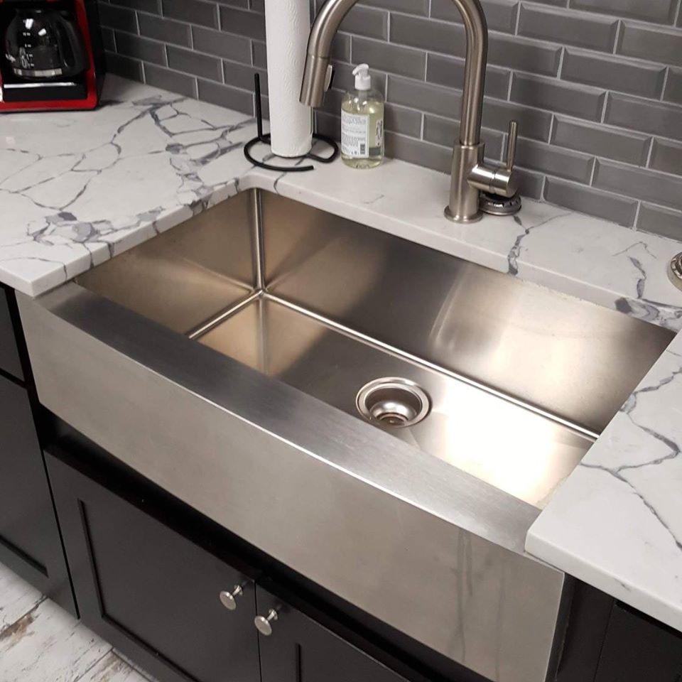 A kitchen sink with a soap dispenser on top of it