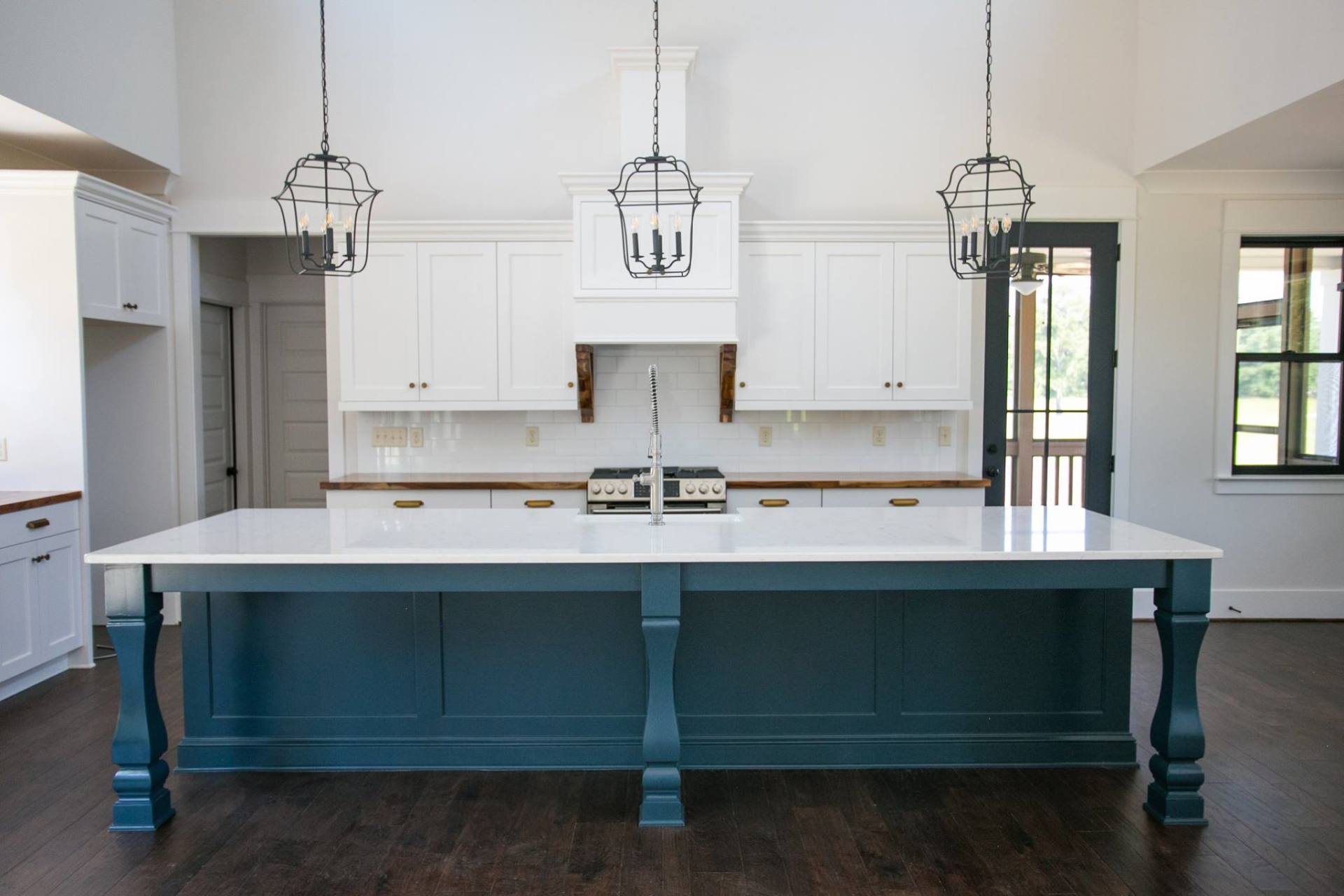 A kitchen with white cabinets and a blue island