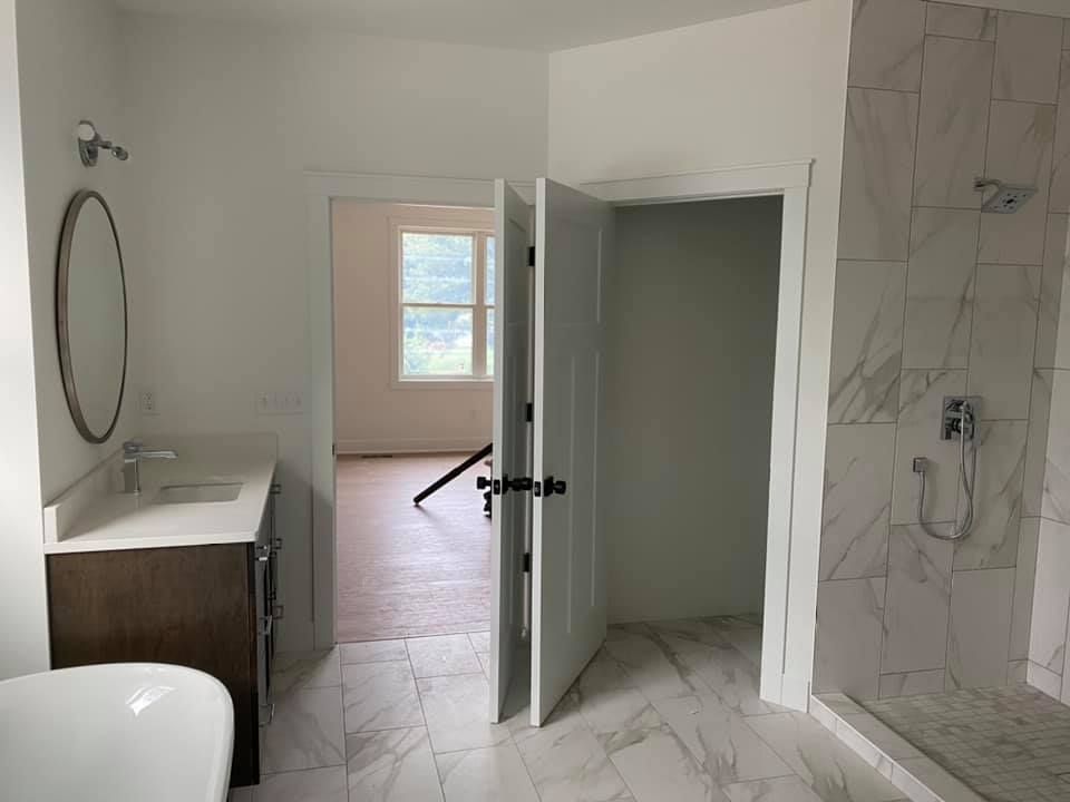A bathroom with a sink , mirror , and shower.