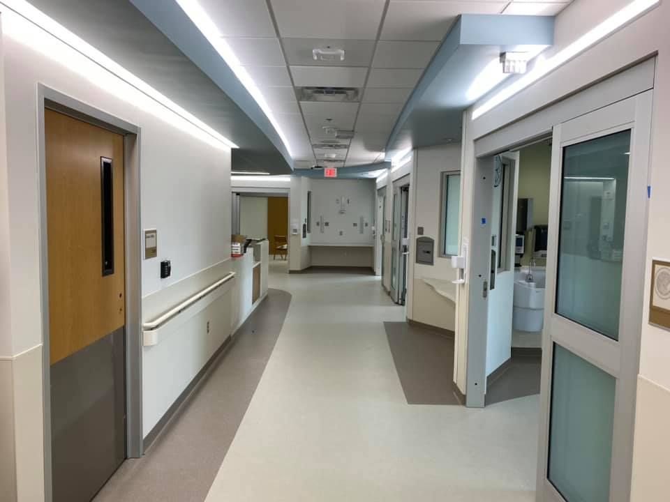 A long hallway in a hospital with a lot of doors