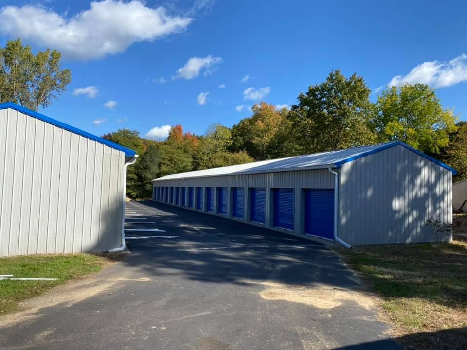 A row of storage units with blue doors on a sunny day.