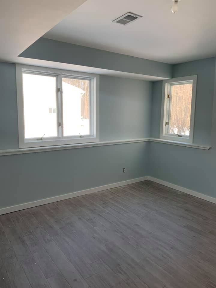 An empty room with a lot of windows and a wooden floor.