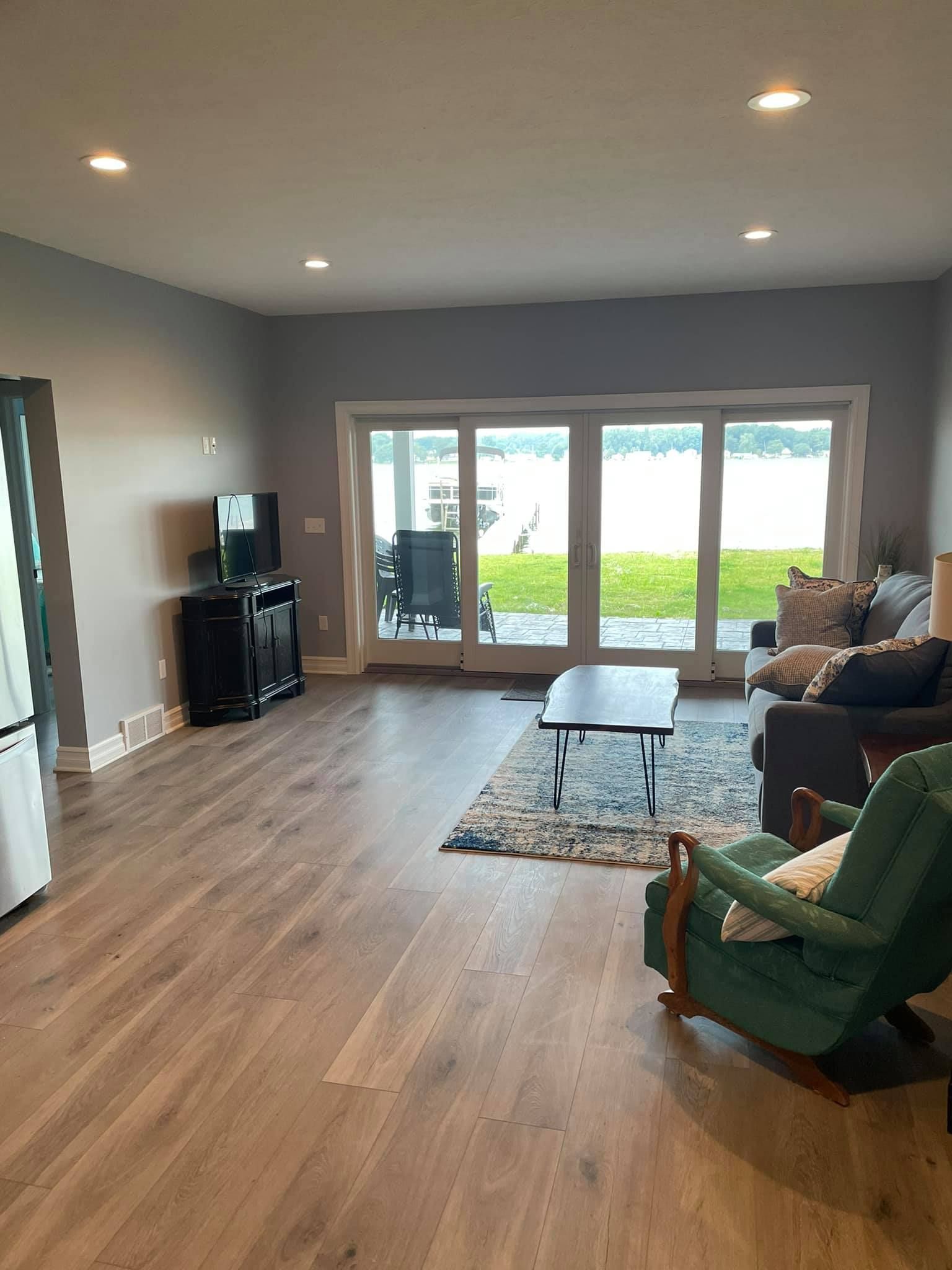 A living room with a couch , chair , coffee table and sliding glass doors.
