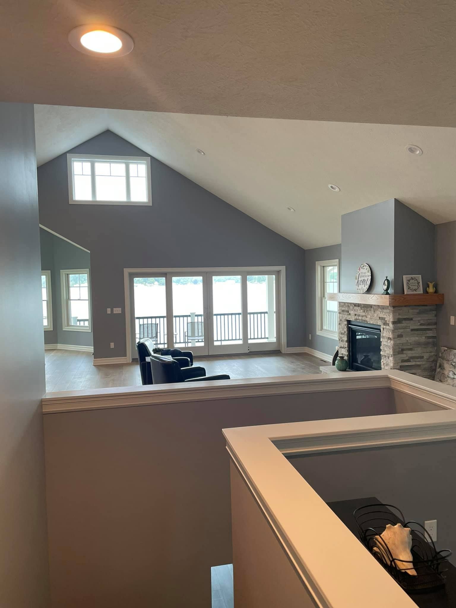 A living room with a vaulted ceiling and a fireplace.