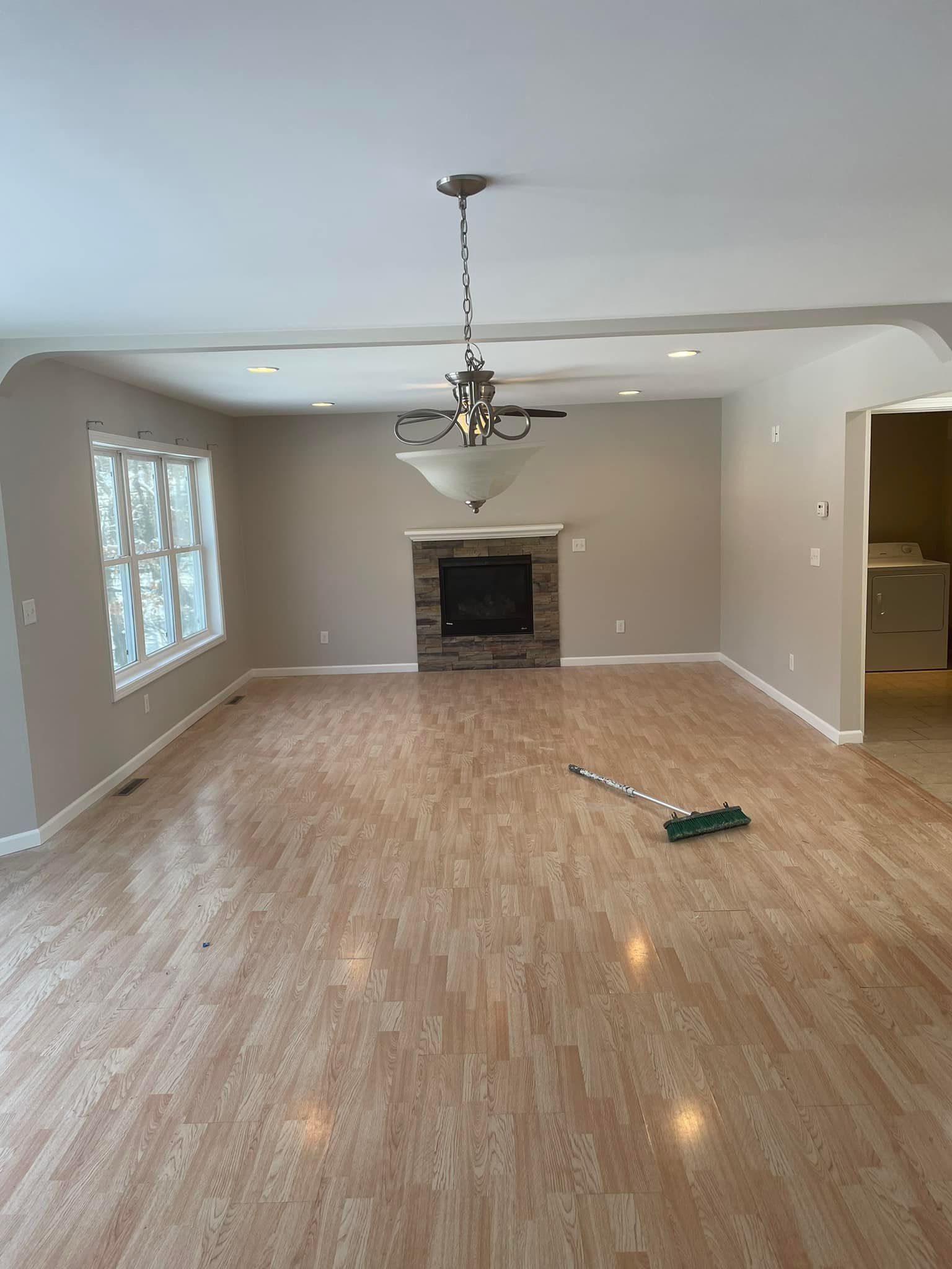 An empty living room with hardwood floors and a fireplace.