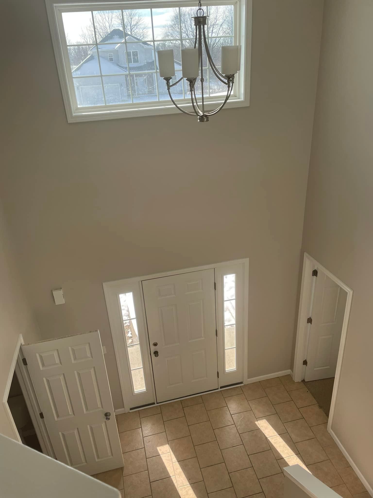 An aerial view of a large empty room with a chandelier hanging from the ceiling.