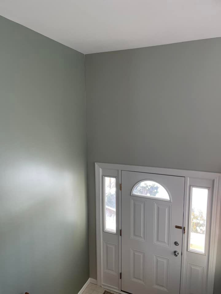 A hallway with a white door and gray walls.
