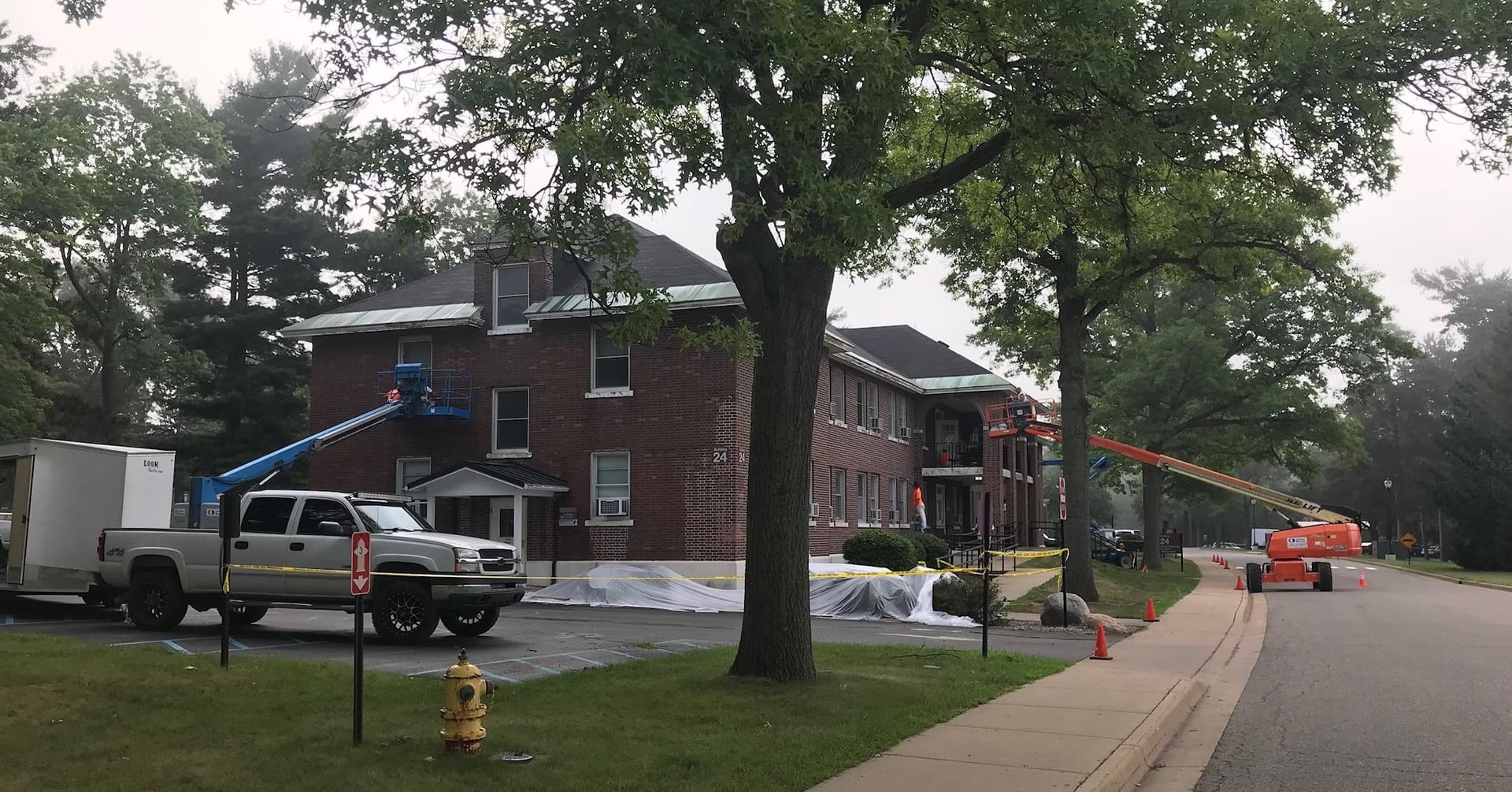 A white truck is parked in front of a brick building.