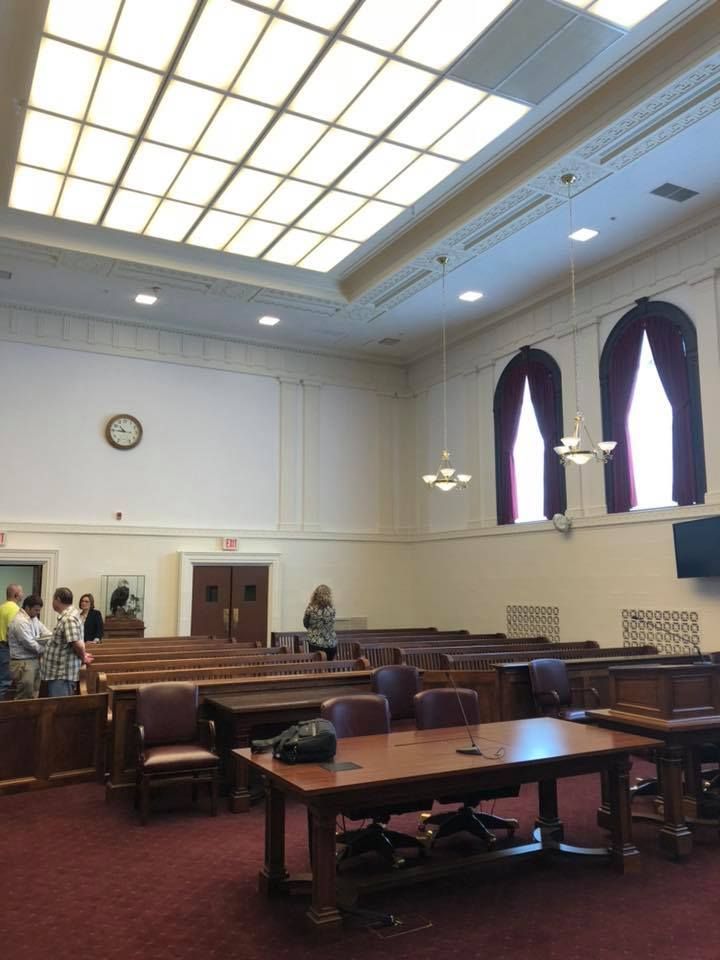 A large room with tables and chairs and a clock on the wall