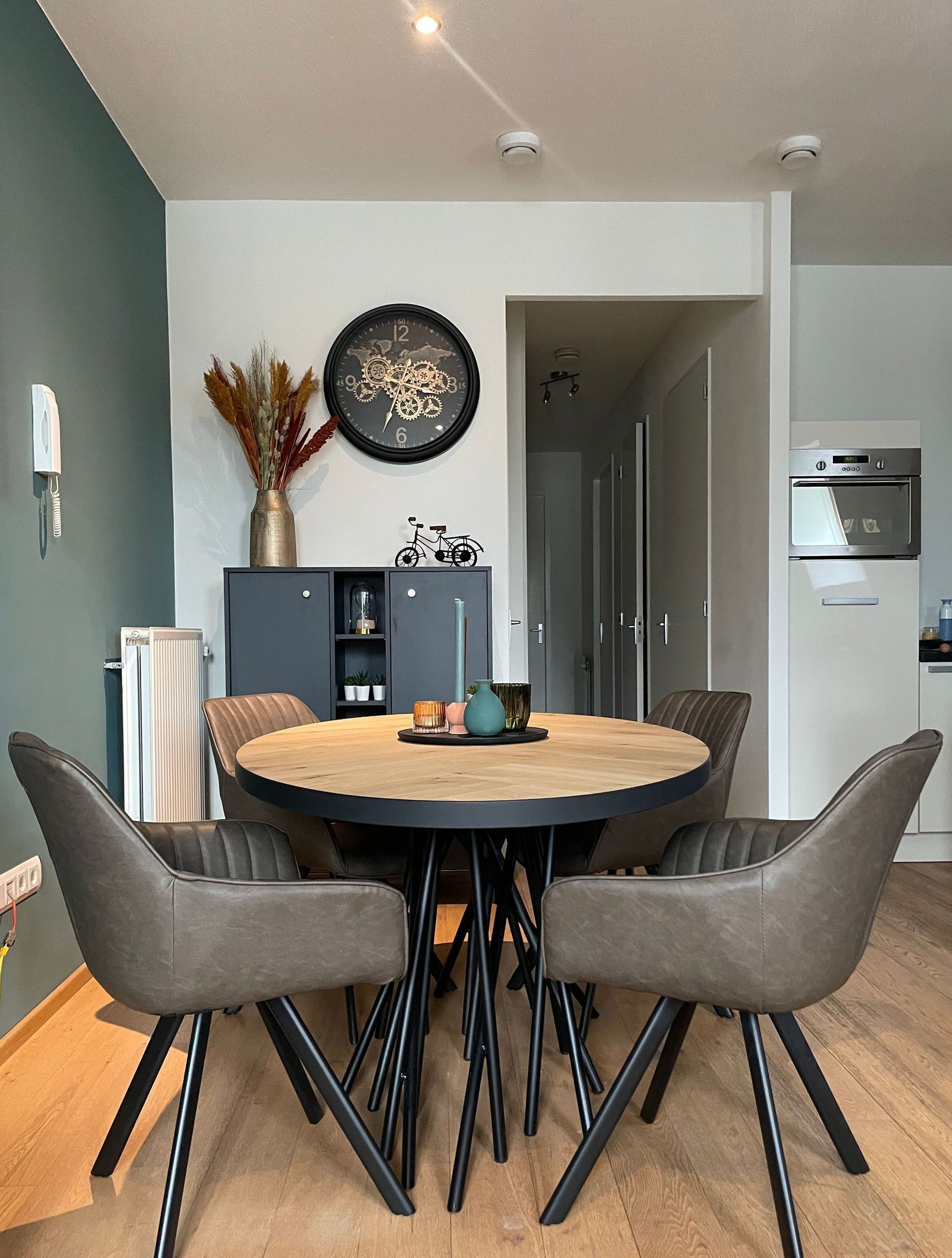 Een eetkamer met een ronde tafel en stoelen