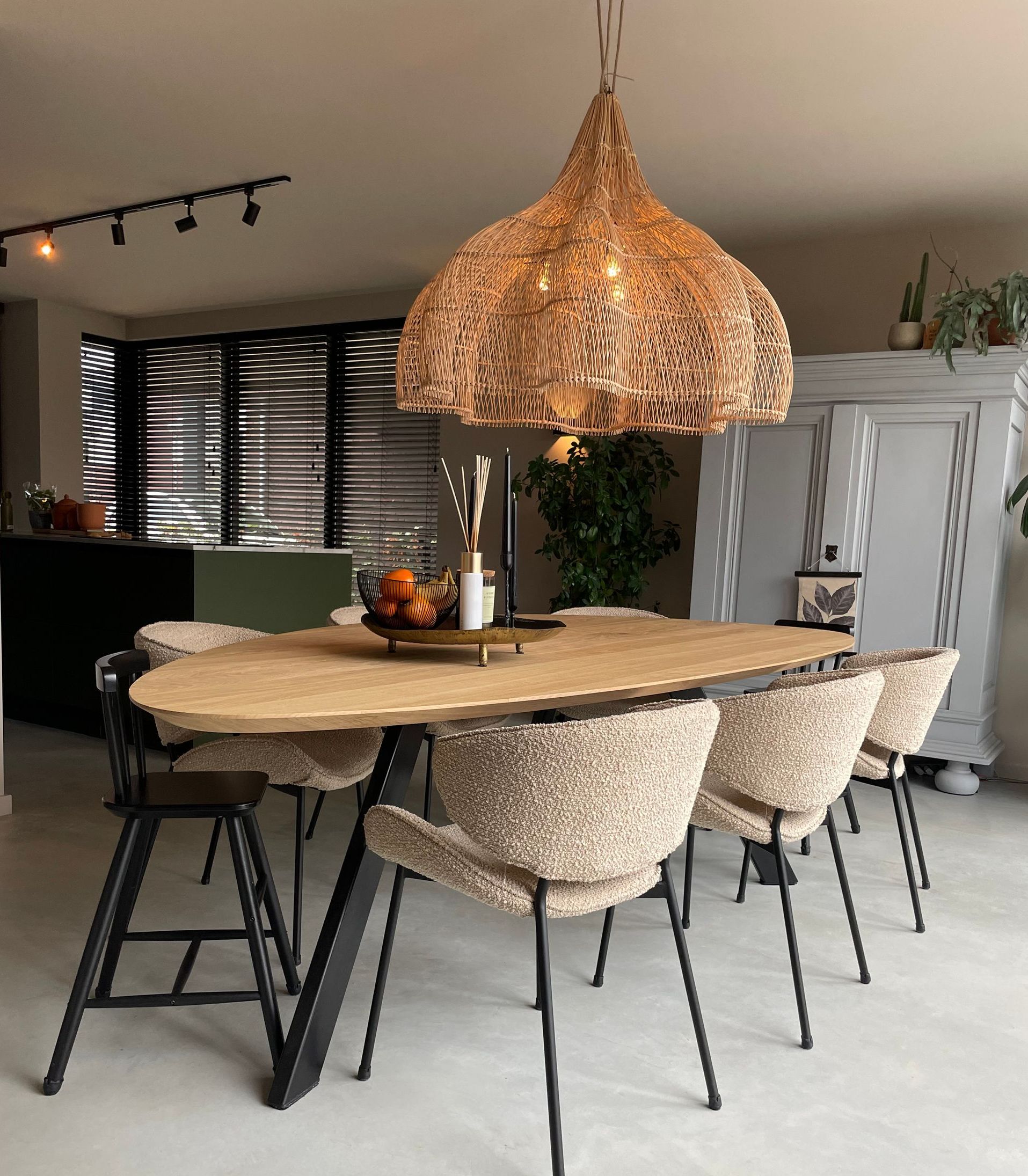 Een eettafel met stoelen en een kroonluchter die aan het plafond hangt.