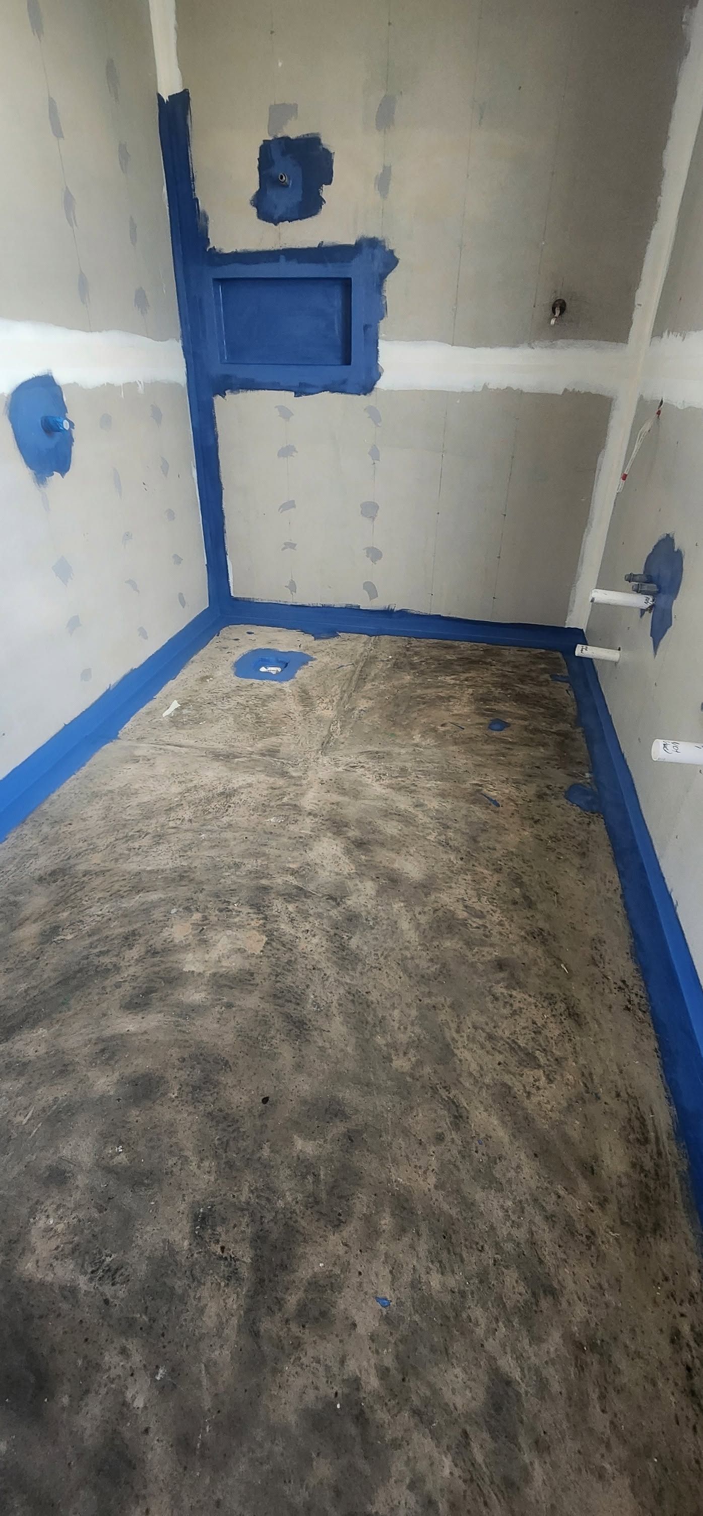 Tall narrow metal-framed rectangular opening on a gray tiled floor