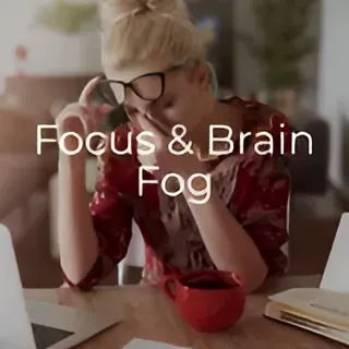 A woman is sitting at a table with a laptop and a cup of coffee