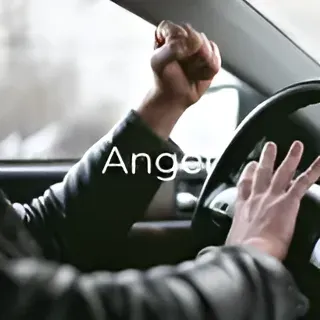 A man is driving a car with his fist in the air