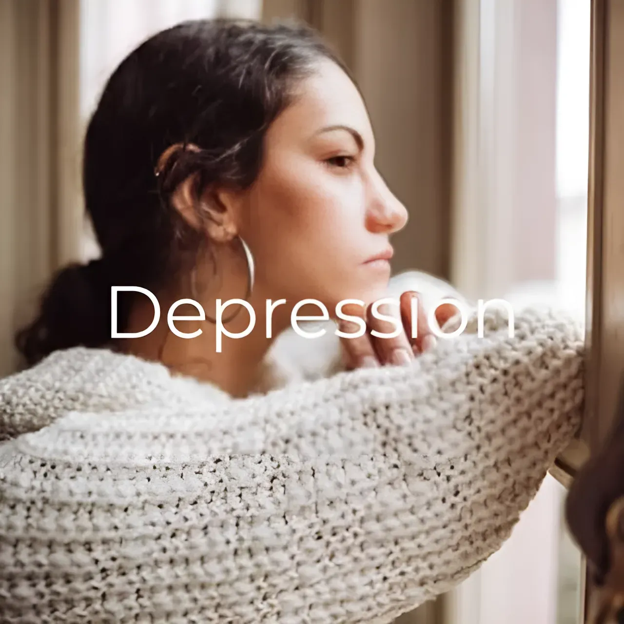 A woman in a sweater is looking out of a window.