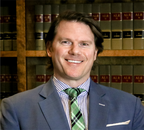 A man in a suit and tie is smiling for the camera.