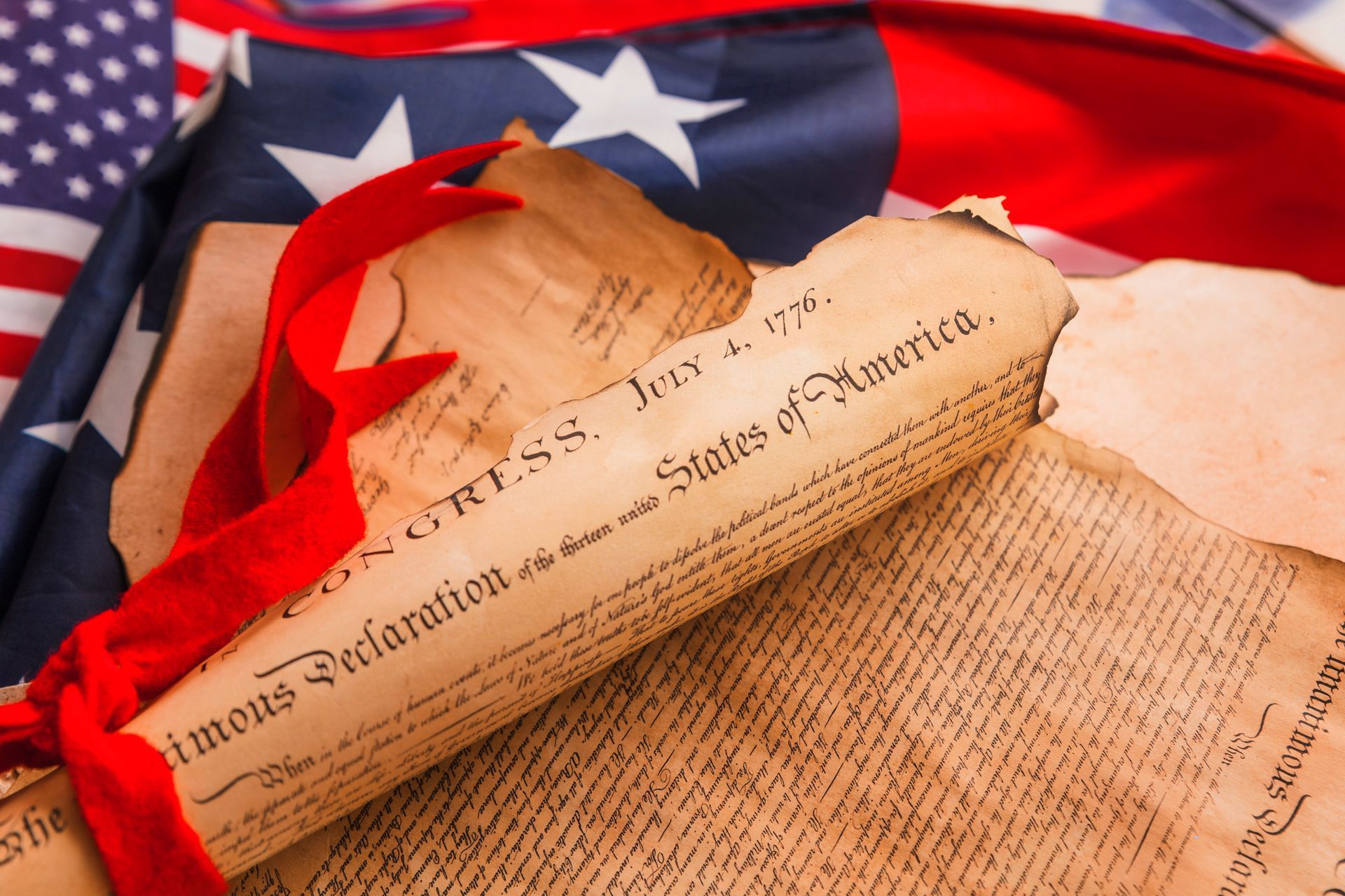 A declaration of independence is laying on top of an american flag