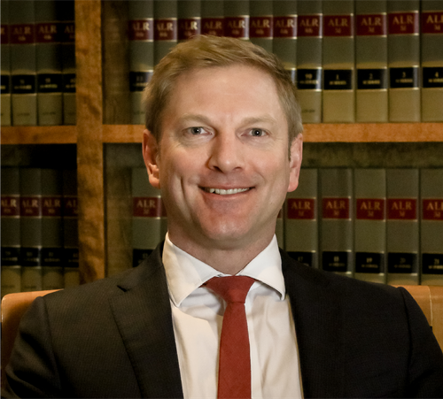 A man in a suit and tie is smiling for the camera.