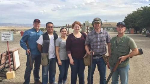 A group of people standing next to each other holding shotguns.