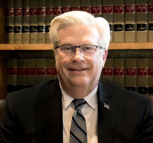 A man in a suit and tie is smiling for the camera.
