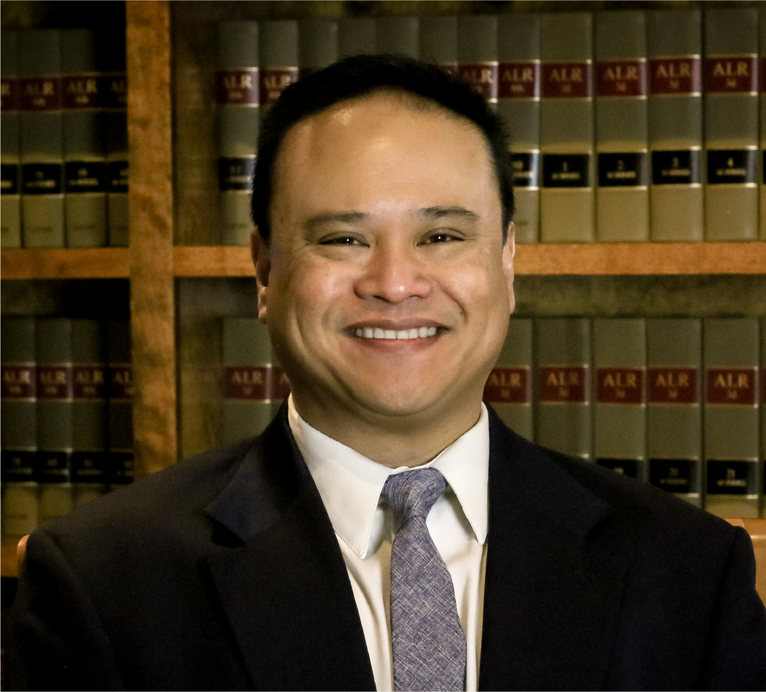 Victor Villegas in a suit and tie is smiling for the camera.