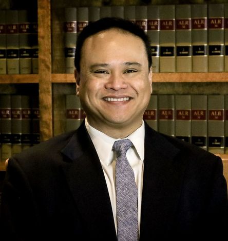 A man in a suit and tie is smiling for the camera.