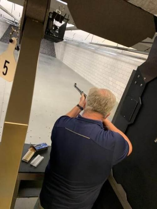 A man shooting a rifle at a firing range.